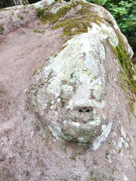 "wajah" penjaga huta/kampung di pahat pada batu.